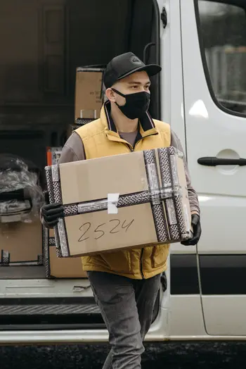 Boy wearing mask pickup box for Cargo Shipping in India