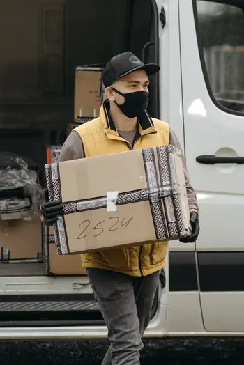 'man with mask delivery box from truck booked by Online truck rental app'